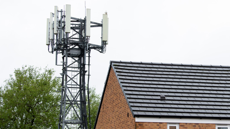 A cell tower mast next to a single-level house