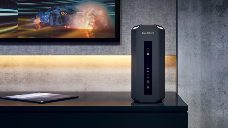 Netgear Nighthawk RS700S Wi-Fi 7 router on entertainment stand below TV.