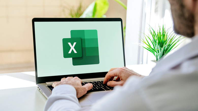 A man using Microsoft Excel on a laptop