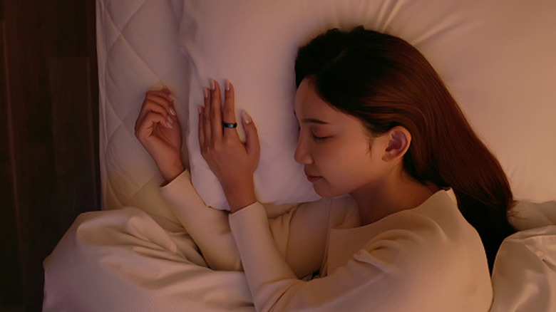 A woman sleeping while wearing a smart ring.