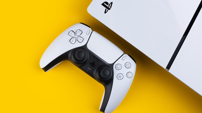 A DualSense and PS5 on a solid yellow background