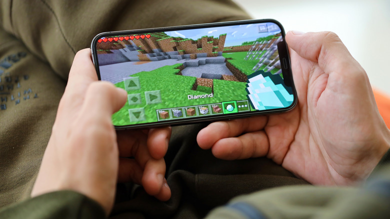 A person playing Minecraft on an iPhone