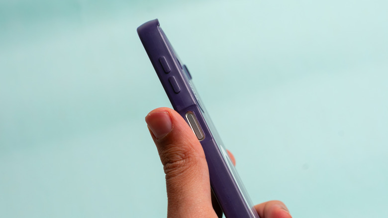 hand holding a phone with cover on, showing the volume button