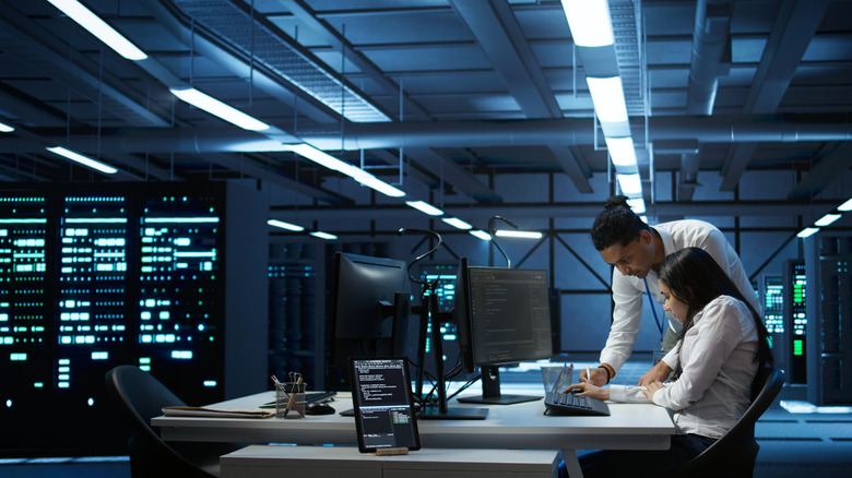 Coworkers at desk working on project in supercomputing center