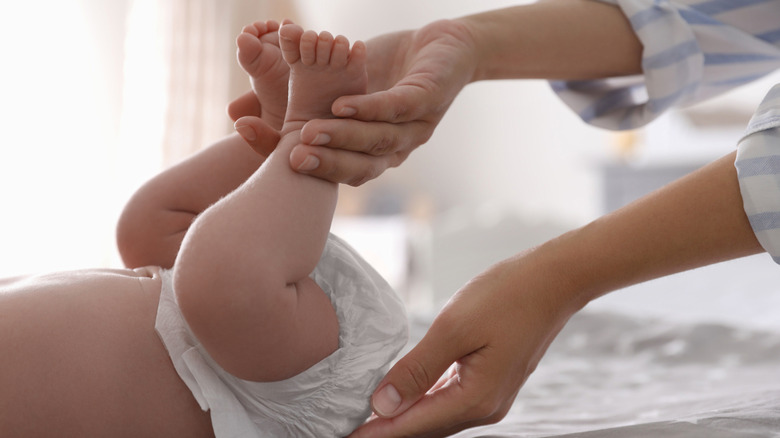 Close-up of hands changing baby's diaper