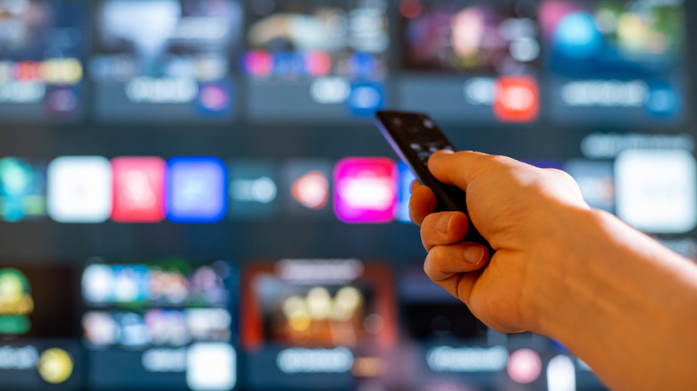 Close-up of hand using remote control to browse TV apps