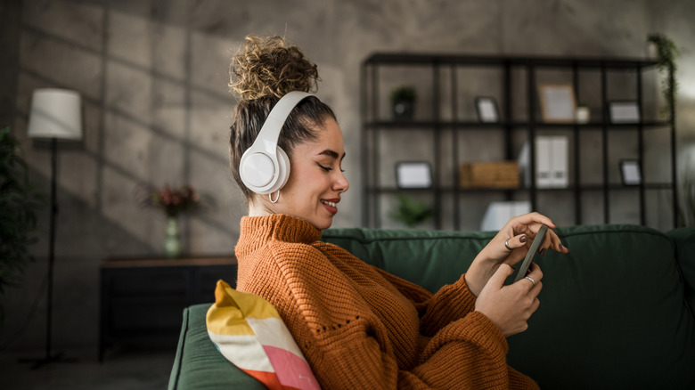 Person using a phone while wearing headphones