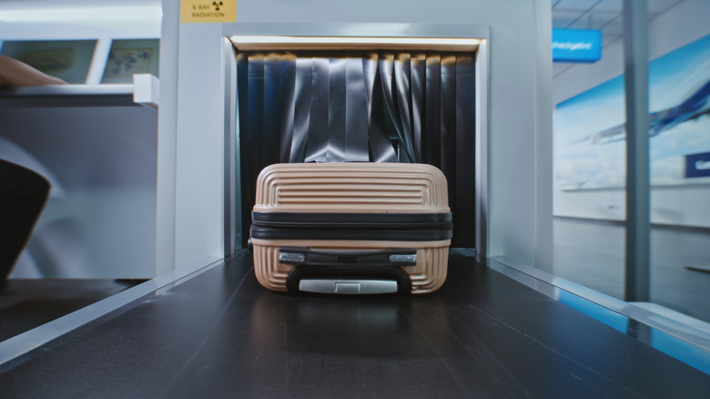 A carry-on bag going through security scan