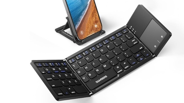 Samsers Foldable Bluetooth Keyboard semi-unfolded on a white background, with a smartphone behind it.