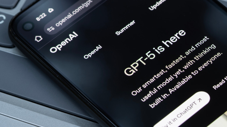 A diagonal shot of a phone with the screen displaying "GPT-5 is here"