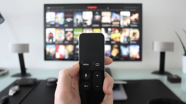TV remote in hand with a smart TV in the background