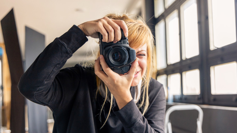 A photographer looking through a DSLR camera
