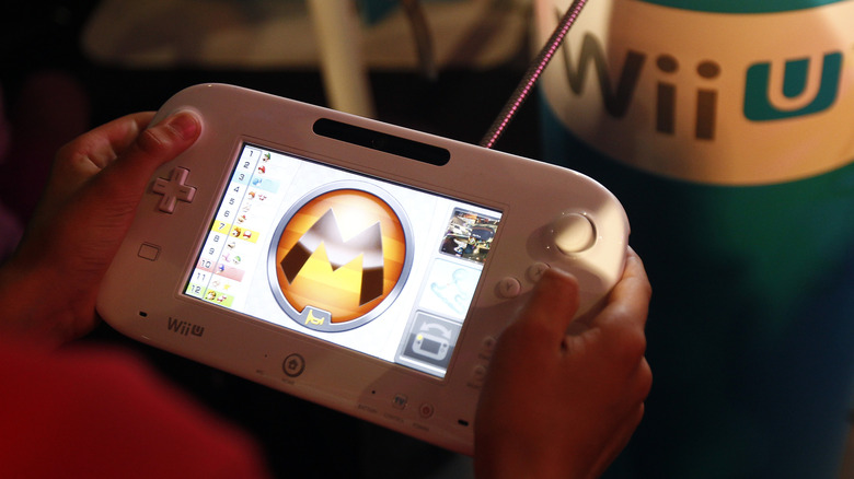 A person playing Mario Kart 8 on a white Wii U gamepad