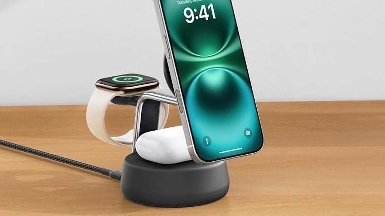 The Belkin Qi2.2 25W Wireless Fast Charging Station charging multiple devices on a wooden surface