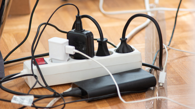 A power strip with lots of connection and a laptop charging brick