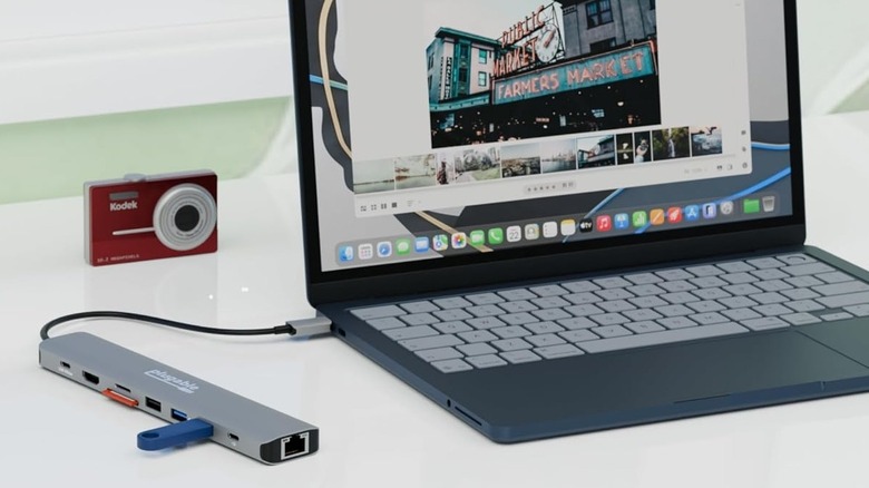 The Plugable 9-in-1 USB-C Hub connected to laptop on a white surface with a Kodak camera in the background