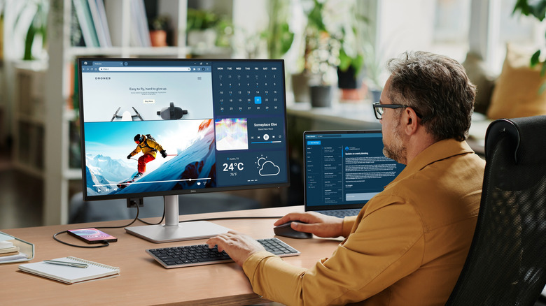 A person using the Dell S2725DC monitor with a MacBook