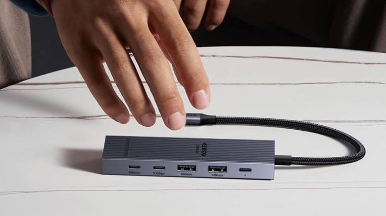 A person about to pick up the Ugreen Revodok Pro USB-C hub