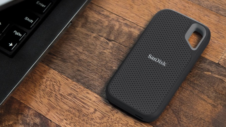 The SanDisk Extreme Go Portable SSD placed on a desk, beside a laptop.