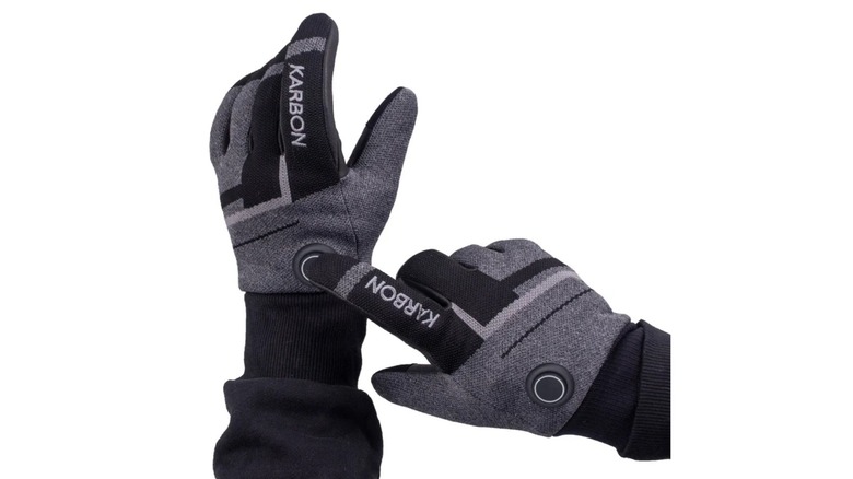 A person wearing the Karbon 3D Knit Heated Gloves, pressing a button on one of them.