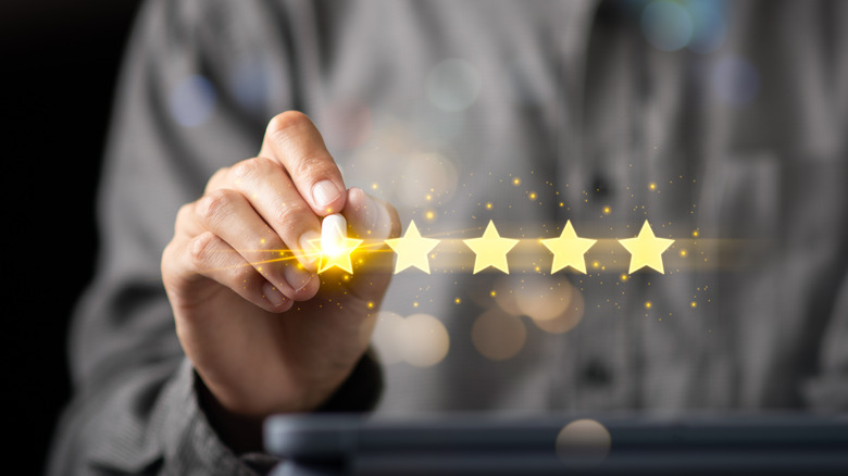 Hand giving five-star rating