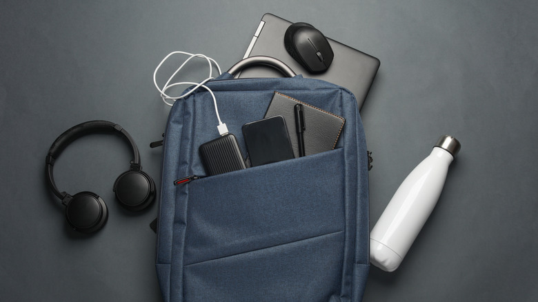 A laptop bag with various devices tucked into its pockets is pictured.