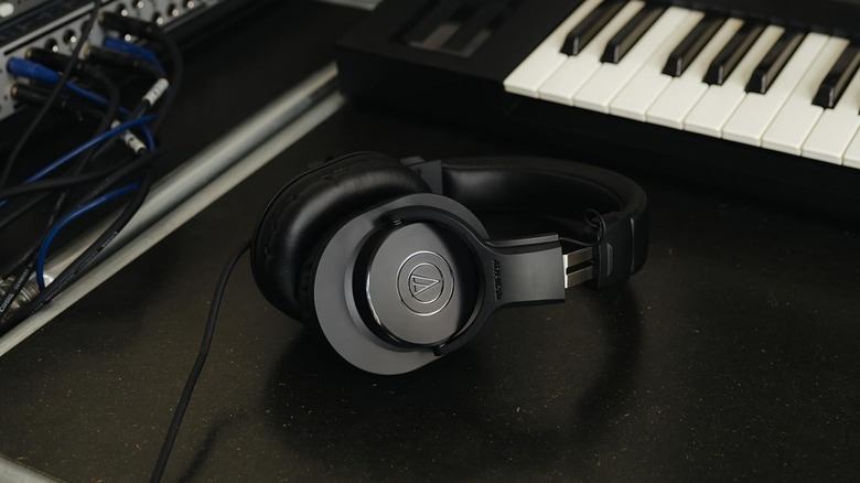 Audio-Technica ATH-M20X headphones kept on a desk beside a keyboard.