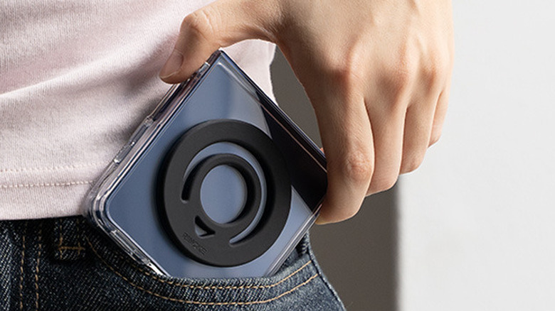Ring grip attached to a foldable phone case as the device is slipped into a jeans pocket.