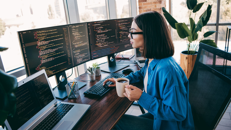 Person using two monitors connected to a laptop