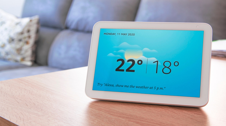 An Echo Show smart display placed on a table in a living room.