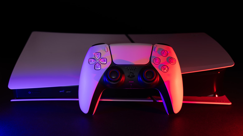 A PlayStation 5 console in the dark with a DualSense controller in front