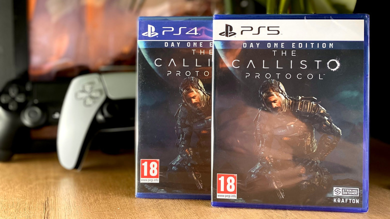 A PlayStation 4 and PlayStation 5 copy of The Callisto Protocol next to controllers