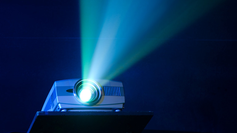 A projector projecting an image into a dark room.