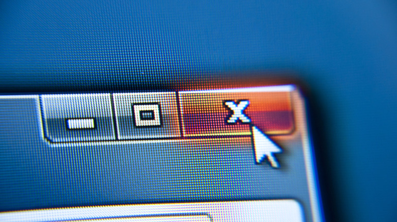Close-up of computer cursor over X symbol, closing out window