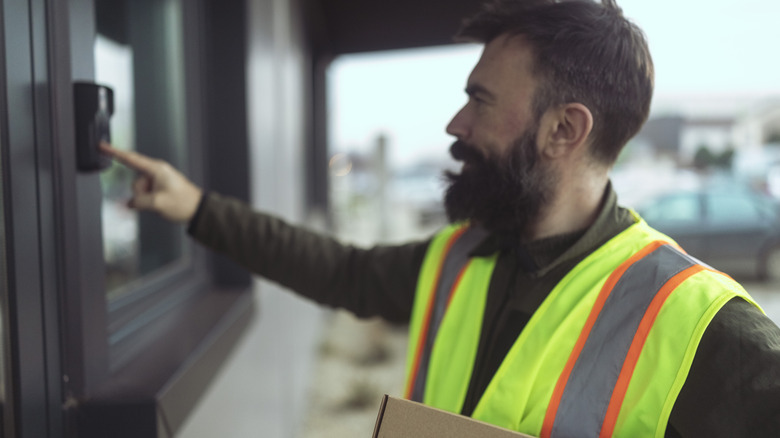 Delivery person ringing a smart doorbell