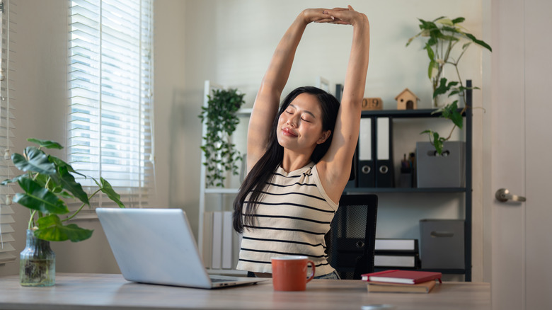 Woman stretching at her desk.