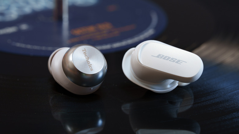 Technics EAH-AZ100 and Bose QuietComfort Ultra Earbuds (2nd Gen) earbuds side-by-side atop a vinyl record.