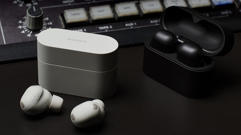 Two pairs of Sony WF-1000XM6 airbuds near a recording mixer.
