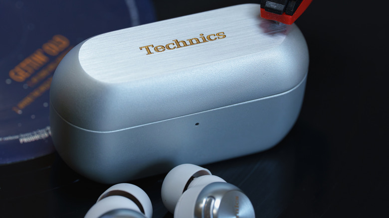 Technics EAH-AZ100 earbuds with their case on top of a vinyl record.
