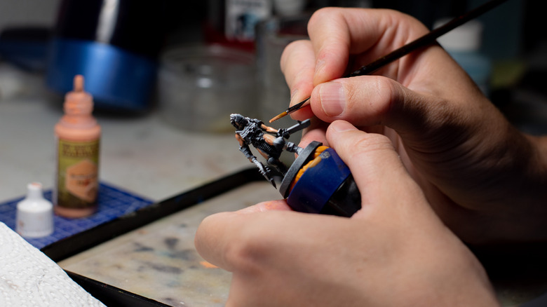 A person painting a miniature figure.