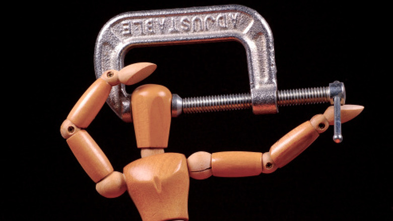 A design mannequin with its head in a vise.