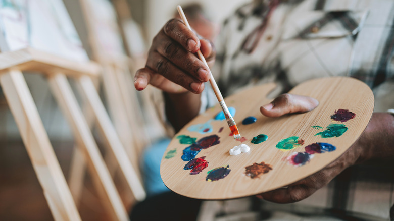 A painter holding a paint palette.