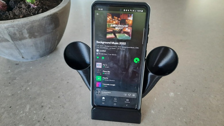 A smartphone on a 3D-printed stand with speakers.