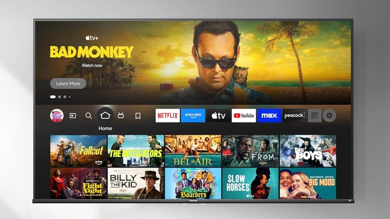 A Hisense Class A7 Series Smart Fire TV mounted on a gray wall, the TV is displaying its operating system's home screen