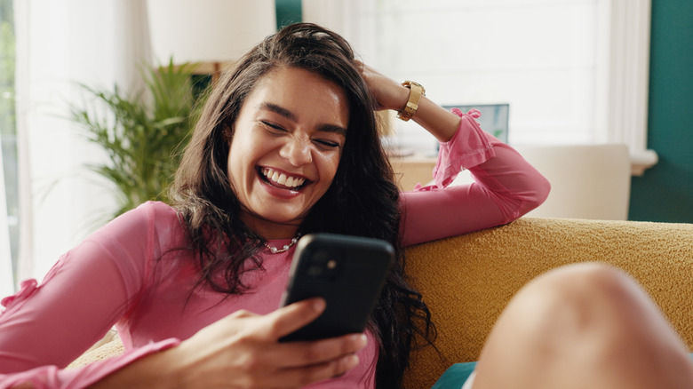 Woman holding phone and laughing
