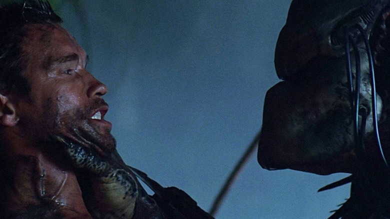 Dutch (Arnold Schwarzenegger) being held by the Predator in Predator
