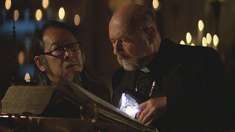 Priest (Donald Pleasance) and  Professor Howard Birack (Victor Wong) in Prince of Darkness looking at a book