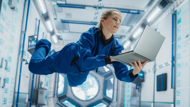 Astronaut using laptop in space