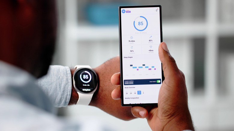 A smartwatch paired with a smartphone to run an app and share information