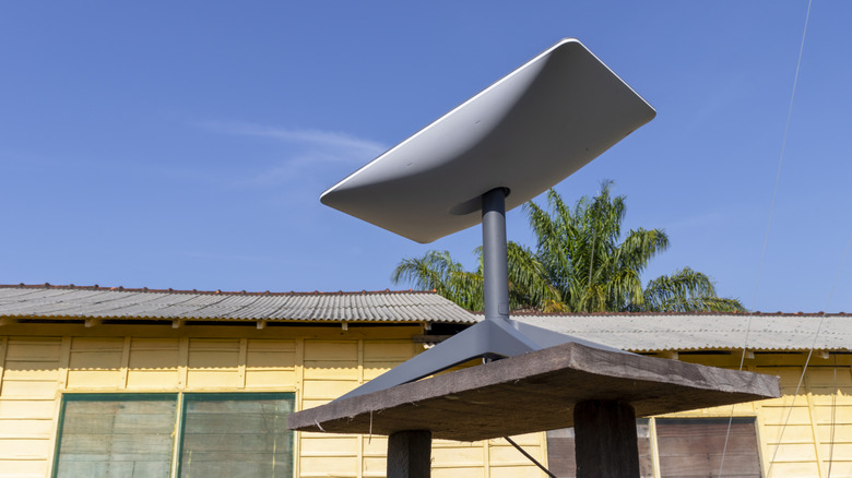 Starlink satellite dish mounted outdoors under a clear blue sky.